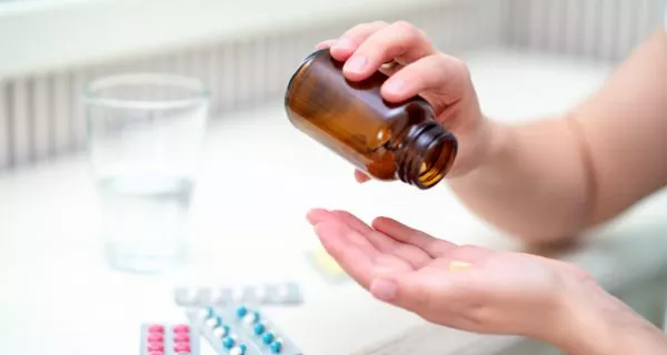 What is carvedilol and why does it cause dry mouth?